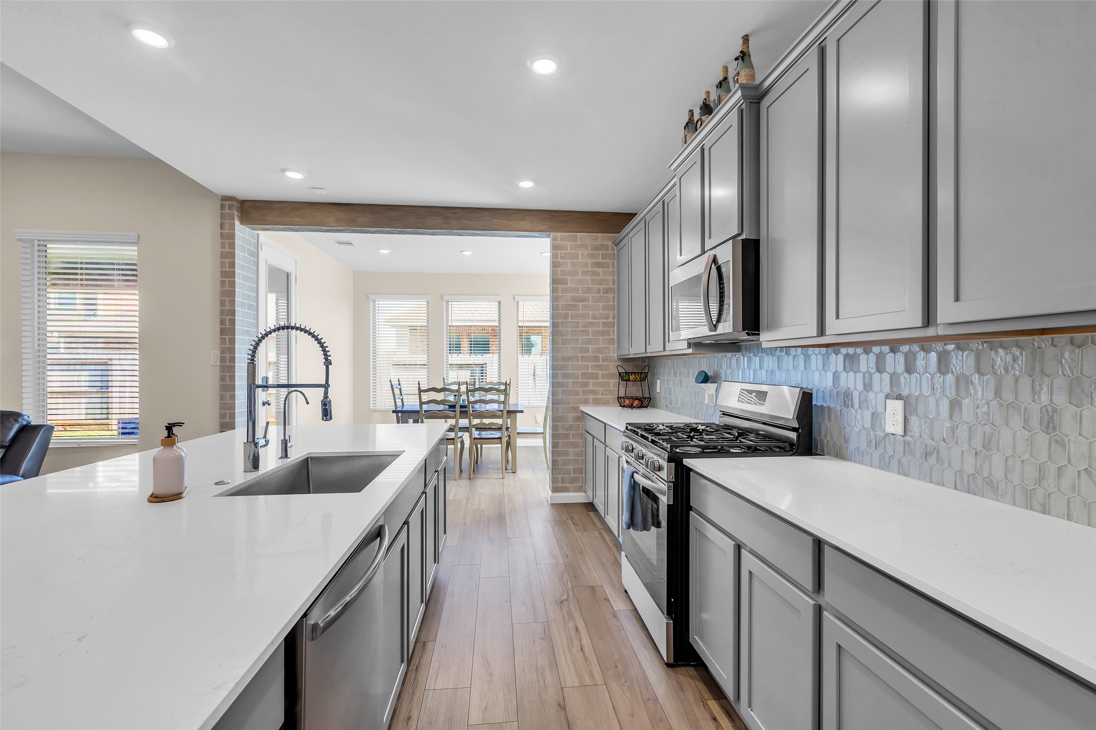 9502 Marble Park Lane Baytown, TX 77521 - Photo 22 of 40 a kitchen with granite countertop a stove a sink a refrigerator and cabinets