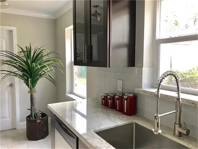 a kitchen with stainless steel appliances granite countertop a sink a stove and a granite counter top