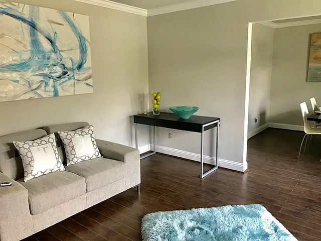 a living room with furniture and wooden floor