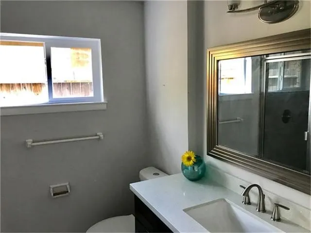 a bathroom with a sink a toilet and a window