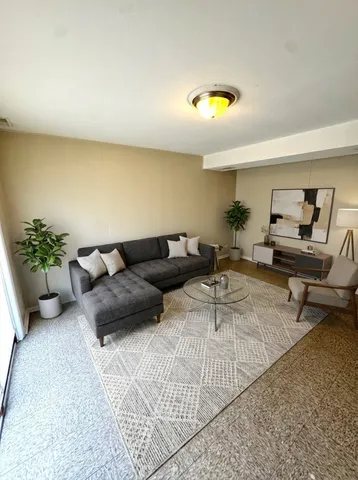 a living room with furniture and a potted plant