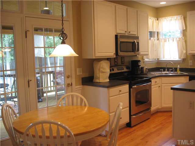 The generous kitchen features updated stainless appliances, recessed lighting, island, walk-in pantry, and sunny breakfast area.