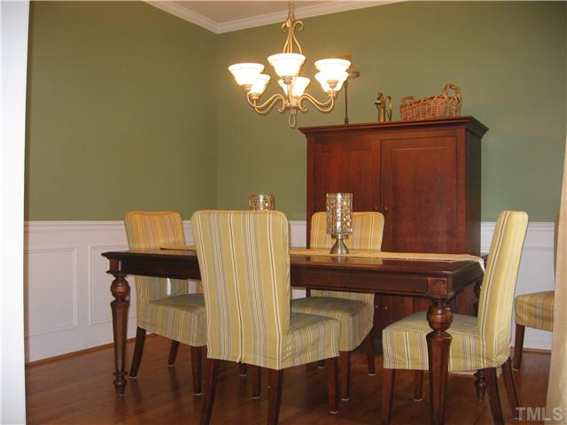 The elegant formal dining room has beautiful refinished hardwood floor, crown molding, wainscoting, and chair rail.