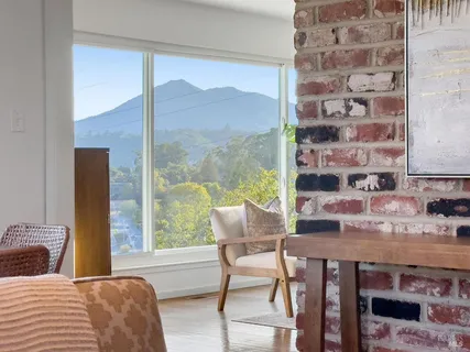 a large kitchen with kitchen island a large window a sink stainless steel appliances and cabinets