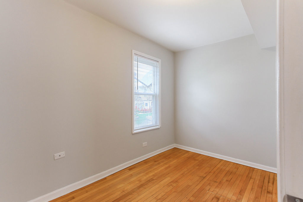 6046 West Giddings Street Chicago, IL 60630 - Photo 11 of 46 a view of an empty room with wooden floor and a window