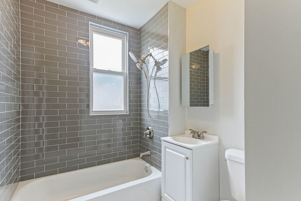 6046 West Giddings Street Chicago, IL 60630 - Photo 23 of 46 a bathroom with a sink a bathtub and window