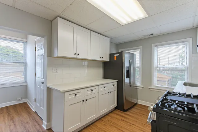 a kitchen with stainless steel appliances granite countertop a stove top oven a sink dishwasher a microwave oven and a refrigerator with wooden floor