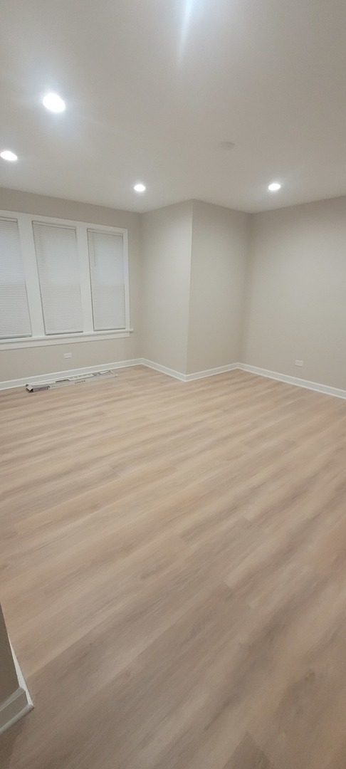 6046 West Giddings Street Chicago, IL 60630 - Photo 40 of 46 an empty room with wooden floor and windows