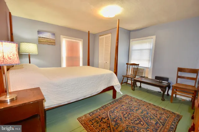 a bedroom with a bed a lamp and a dresser