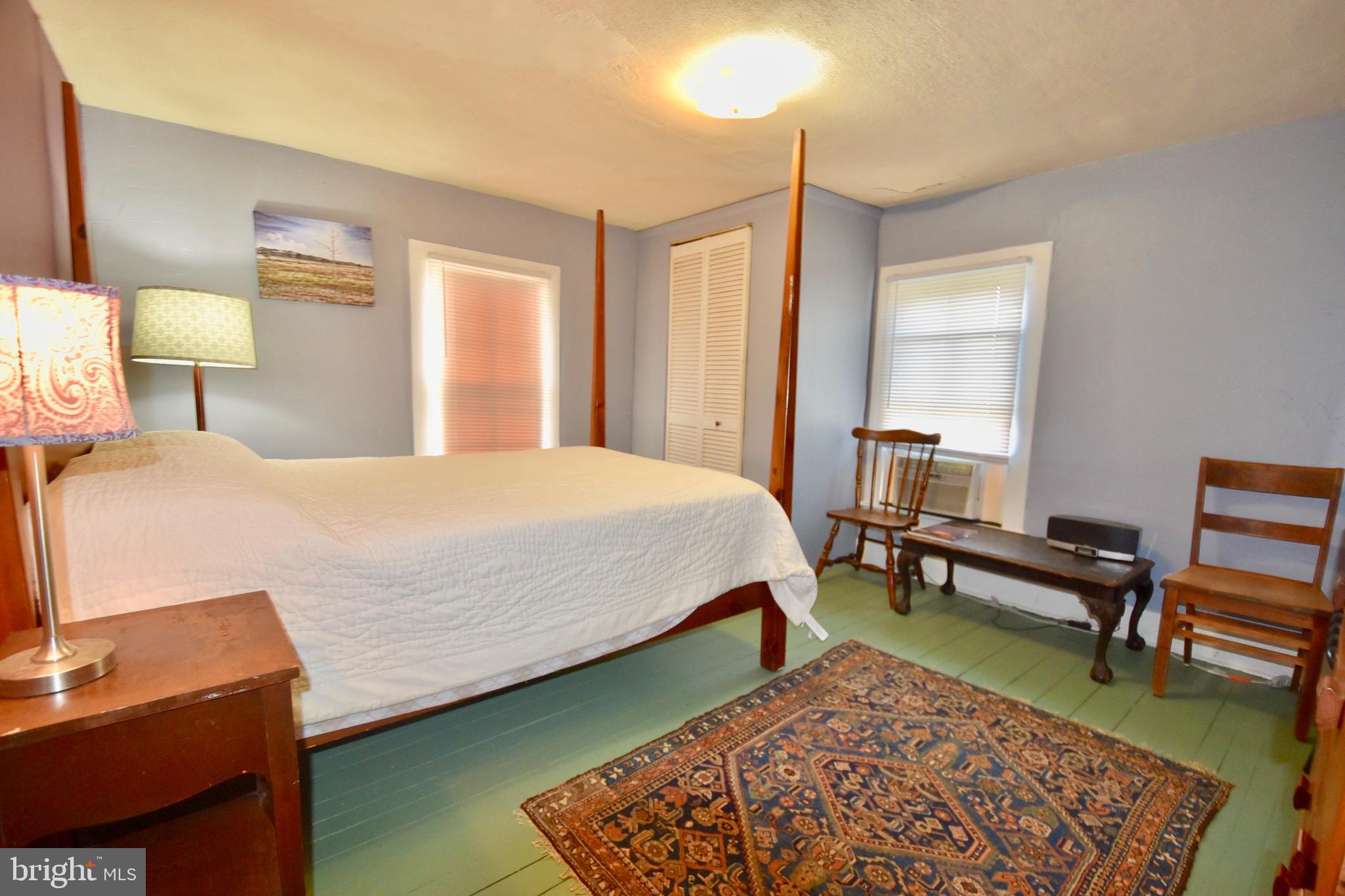 407 Main Street Sharptown, MD 21861 - Photo 21 of 32 a bedroom with a bed a lamp and a dresser
