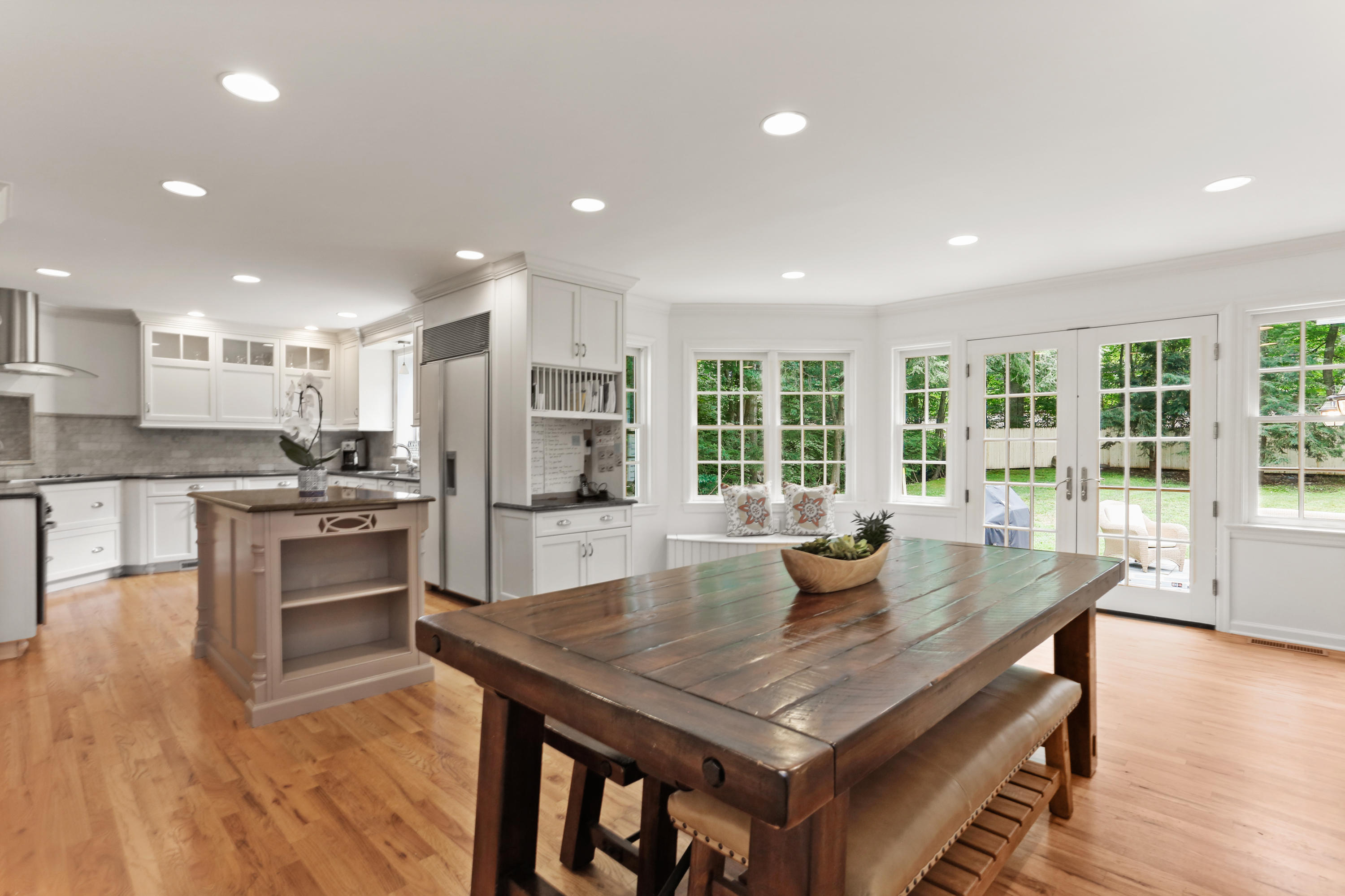 53 Country Club Road Darien, CT 06820 - Photo 12 of 35 a kitchen with stainless steel appliances granite countertop a stove a refrigerator a sink a dining table and chairs with wooden floor