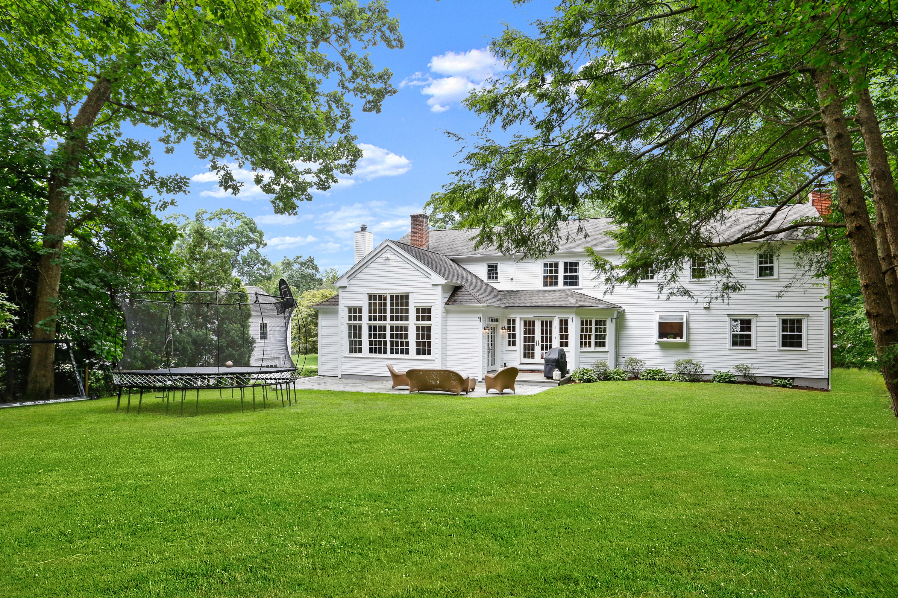 53 Country Club Road Darien, CT 06820 - Photo 31 of 35 a front view of a house with a garden and trees