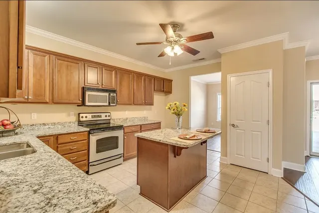 a kitchen with stainless steel appliances granite countertop a stove a sink dishwasher and a refrigerator