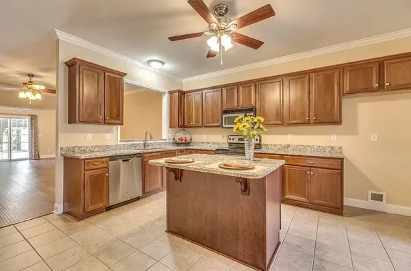 a kitchen with stainless steel appliances granite countertop a sink counter space cabinets and a stove