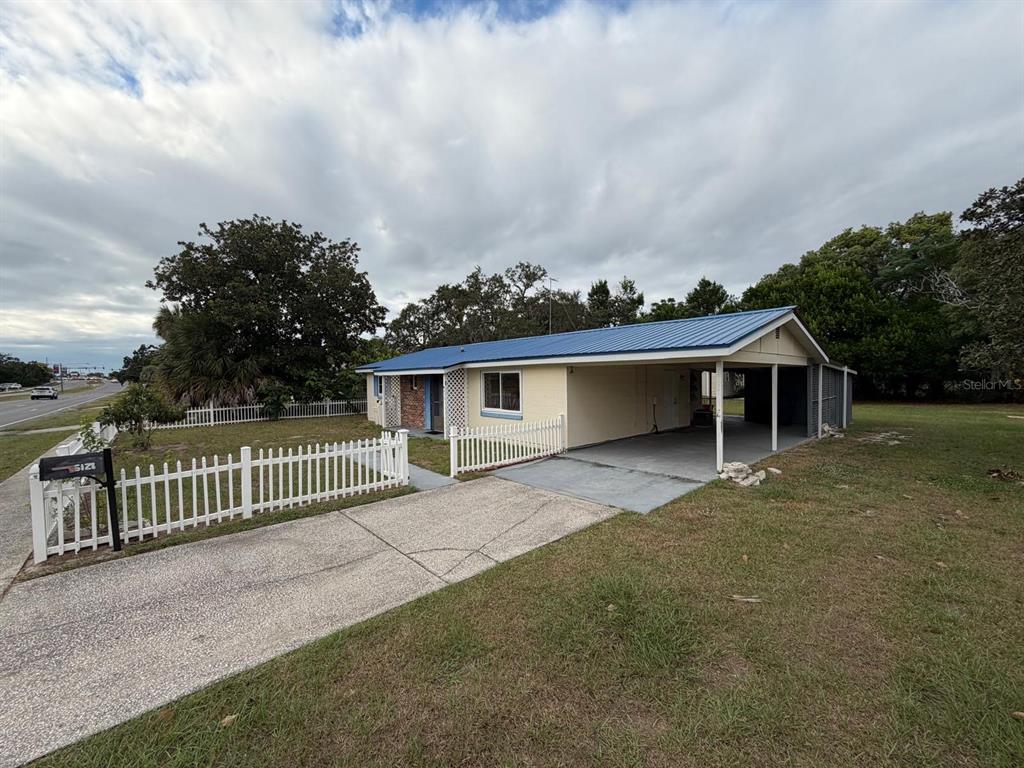 6121 Spring Hill Drive Spring Hill, FL 34606 - Photo 3 of 20 a view of a house with wooden floor and a fence