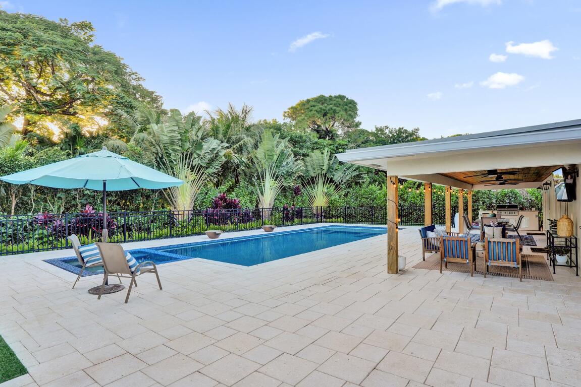 3681 Northwest 24th Terrace Boca Raton, FL 33431 - Photo 56 of 78 a view of a patio with a table and chairs under an umbrella