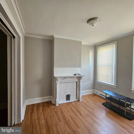 an empty room with a fireplace and wooden floor