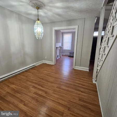 a view of a room with wooden floor and chandelier