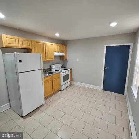 a kitchen with a refrigerator a stove top oven and a refrigerator