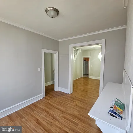 an empty room with wooden floor and bathroom