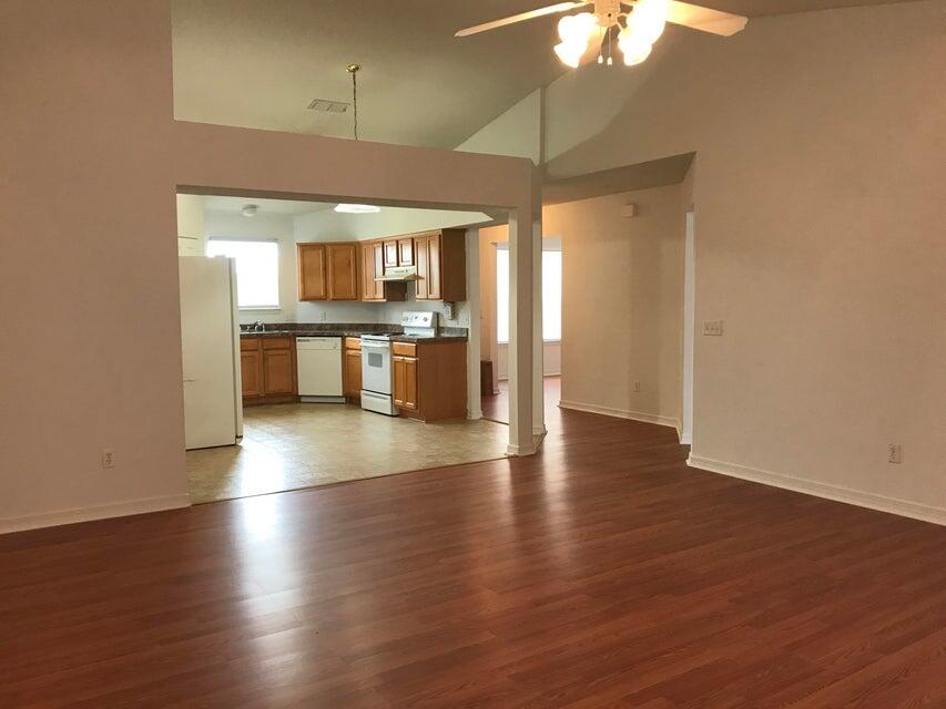 294 Limestone Circle Crestview, FL 32539 - Photo 3 of 9 an empty room with wooden floor and chandelier