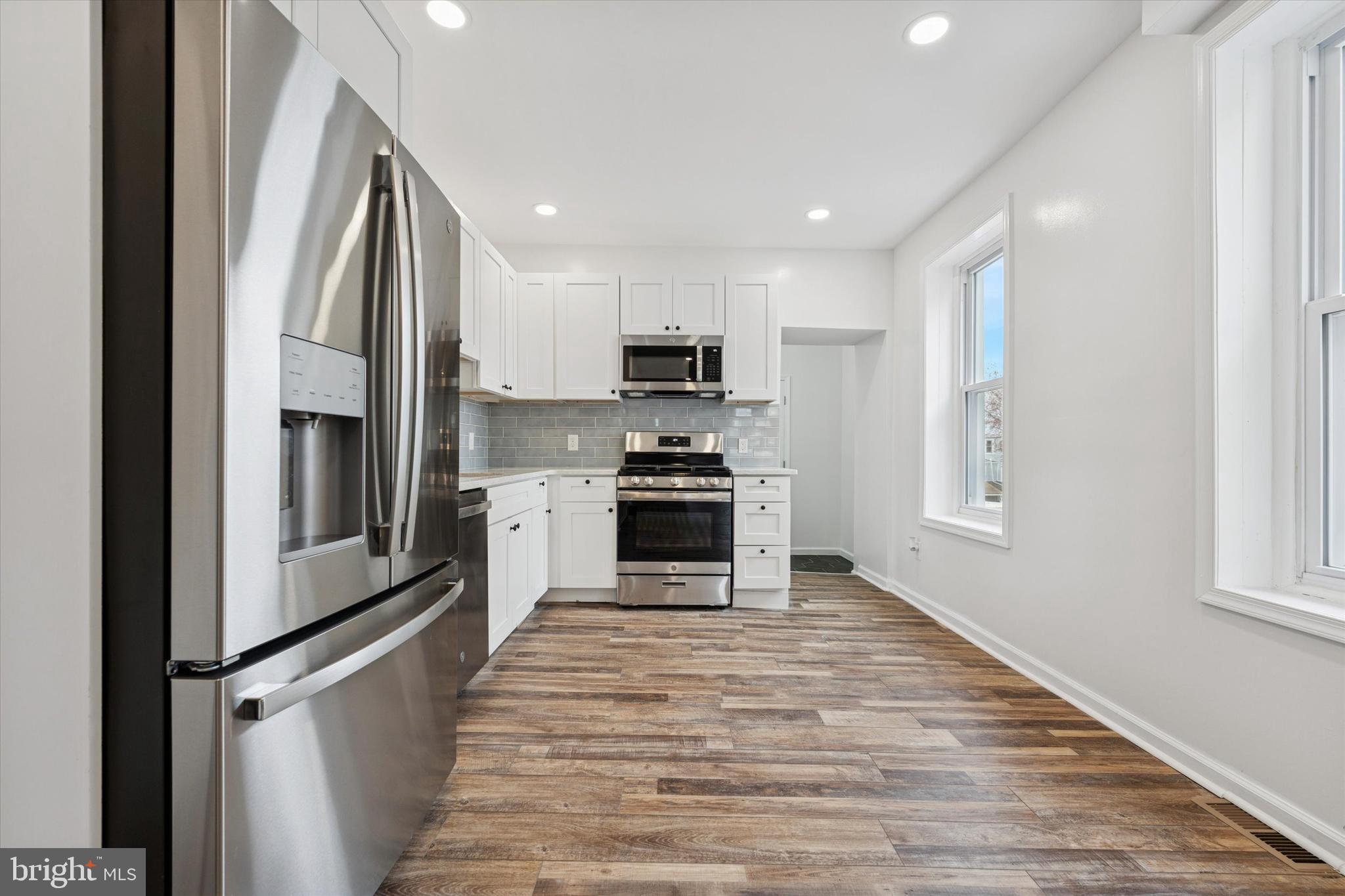 425 Grove Street Bridgeport, PA 19405 - Photo 6 of 24 a kitchen with granite countertop a refrigerator and a stove top oven