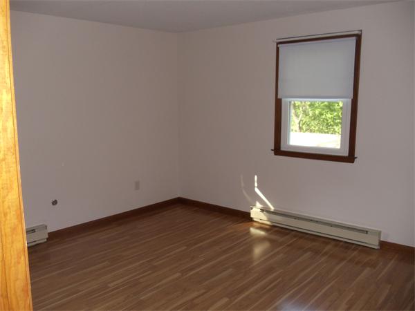 17 Meadow Road Ware, MA 01082 - Photo 9 of 15 a room with wooden floor a exposed radiator and a window