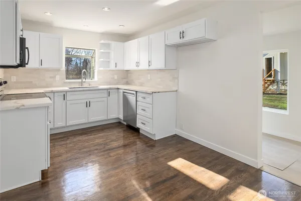 a kitchen with granite countertop white cabinets and white appliances