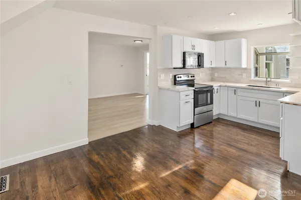 a kitchen with granite countertop a stove a sink and a refrigerator