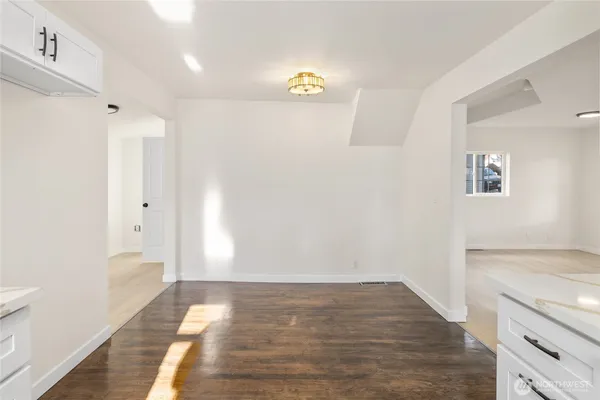 a view of empty room with wooden floor and window