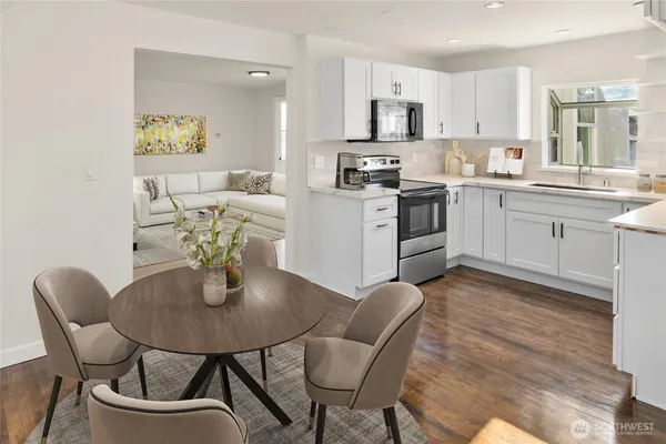 a kitchen with a dining table chairs and white appliances