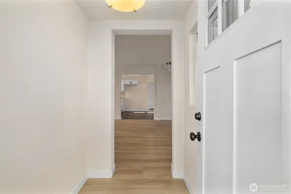 a view of a hallway with wooden floor and closet