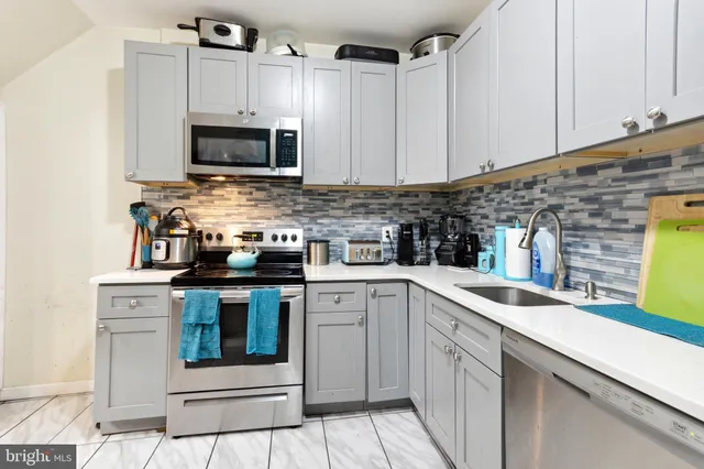 a kitchen with stainless steel appliances granite countertop a sink stove and microwave