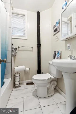 a bathroom with a sink toilet and mirror
