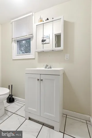 a bathroom with a sink a toilet and mirror