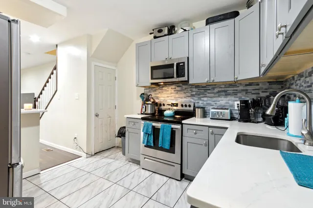 a kitchen with stainless steel appliances a stove a sink and a microwave