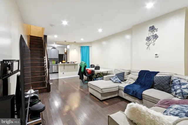 a living room with furniture kitchen view and a flat screen tv
