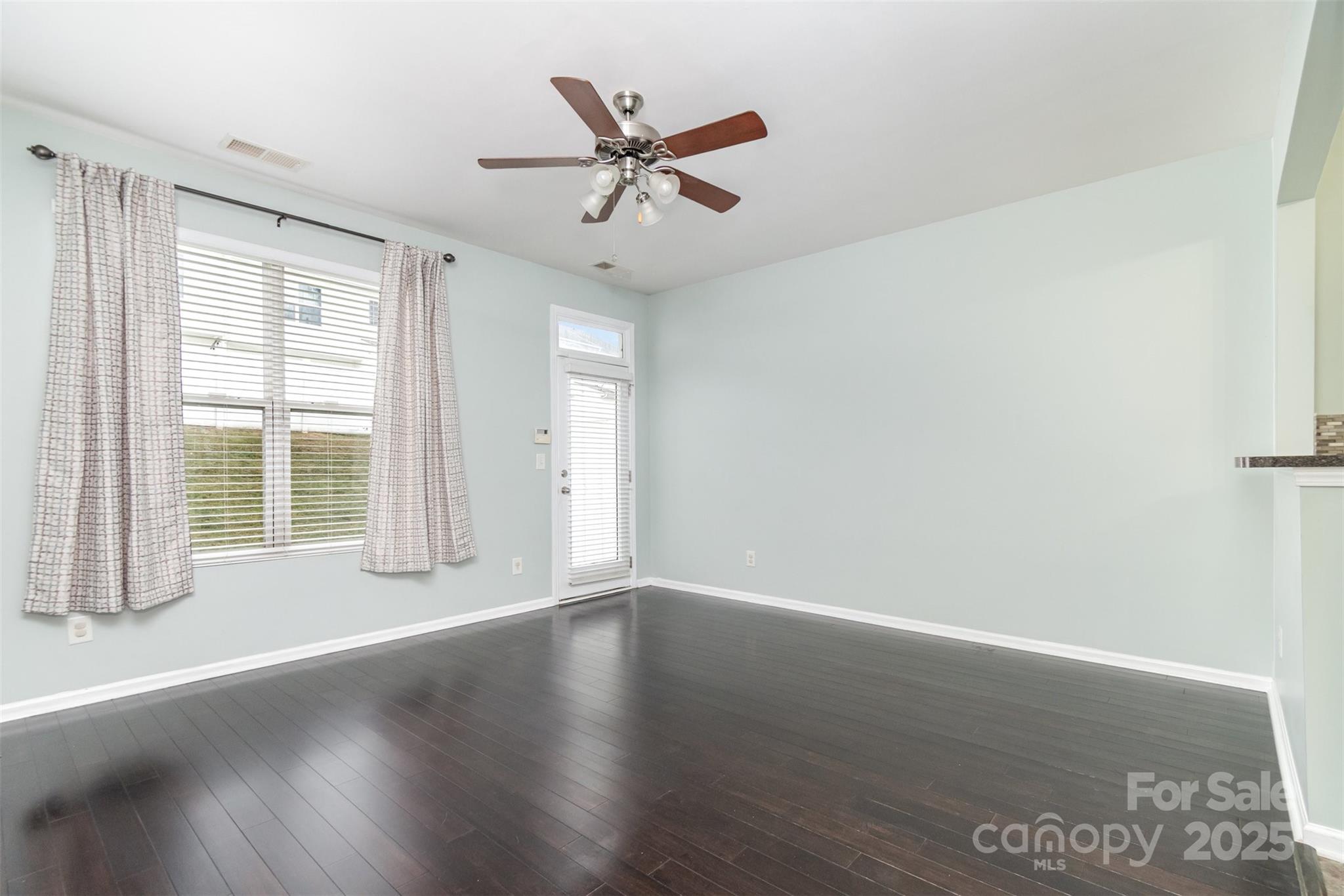 7367 Laurel Valley Road Charlotte, NC 28273 - Photo 7 of 21 an empty room with wooden floor fan and windows