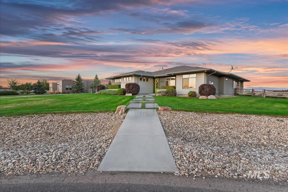 24398 Tombstone Ridge Court Middleton, ID 83644 - Photo 45 of 48 Contemporary exterior with a covered entry, expansive green lawn, and a long concrete pathway