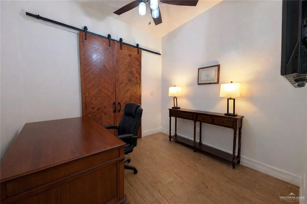 805 Grayson Avenue McAllen, TX 78504 - Photo 13 of 31 a view of a workspace with furniture and a flat screen tv