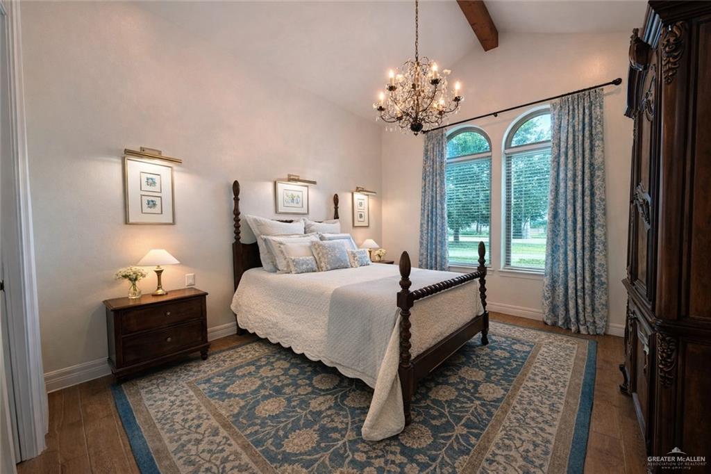 805 Grayson Avenue McAllen, TX 78504 - Photo 14 of 31 a bedroom with a bed table and a chandelier