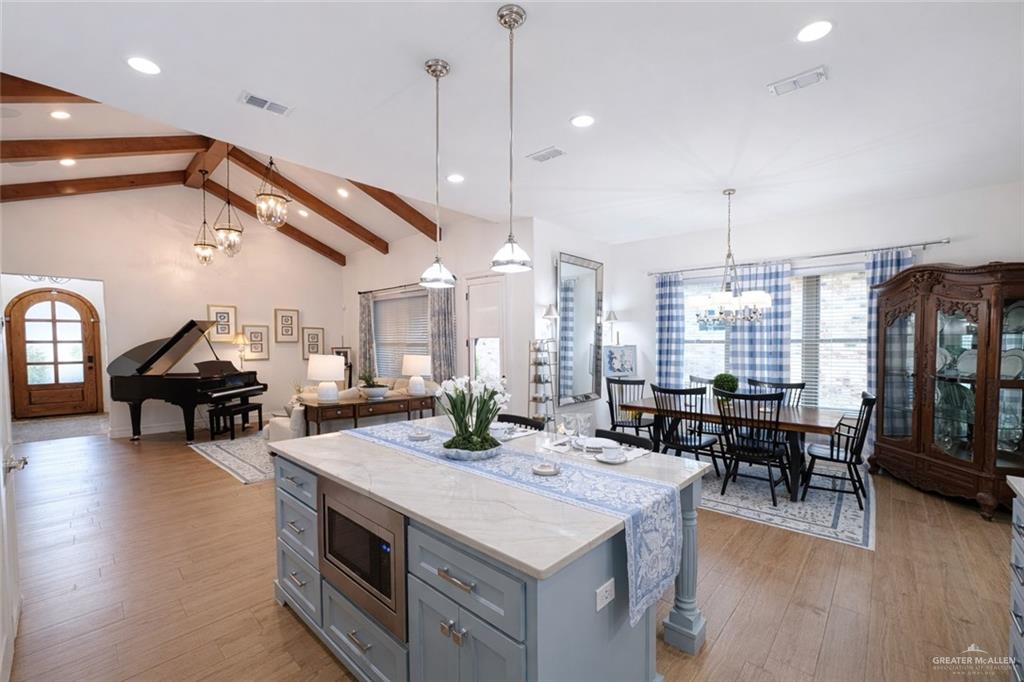 805 Grayson Avenue McAllen, TX 78504 - Photo 5 of 31 a open kitchen with stainless steel appliances kitchen island granite countertop a stove and a dining table with wooden floor