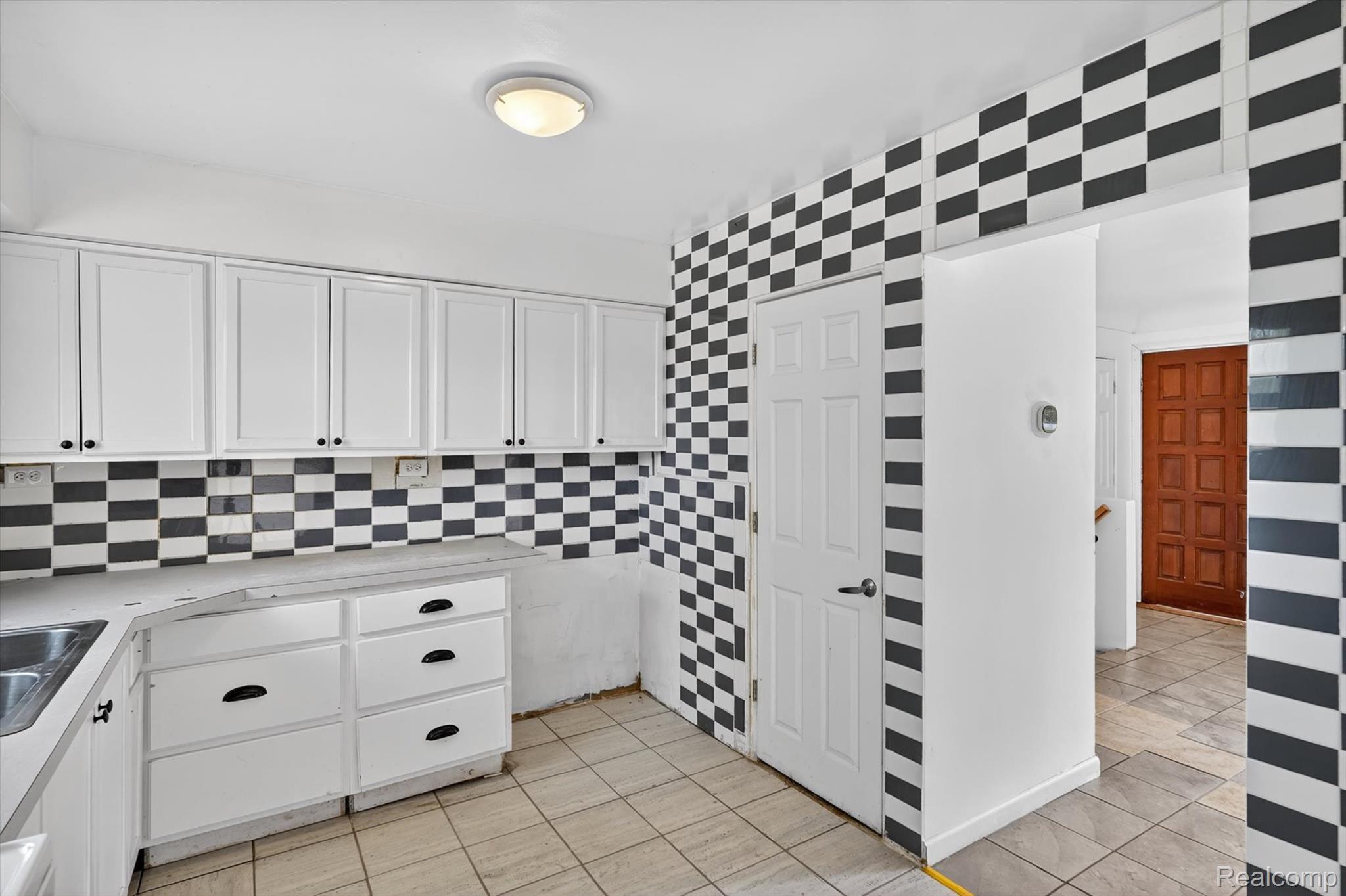 5457 East Frances Road Mount Morris, MI 48458 - Photo 15 of 42 Kitchen with white cabinets, light countertops, decorative backsplash, and light tile patterned flooring