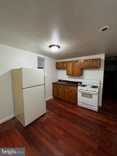 2216 North Broad Street, Unit 2R Philadelphia, PA 19132 - Photo 2 of 4 a kitchen with wooden floors and white appliances