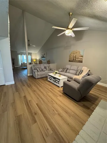a living room with furniture and a ceiling fan