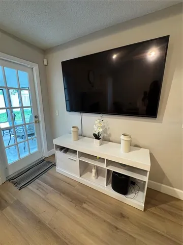 a view of living room with stainless steel appliances wooden floor and large window
