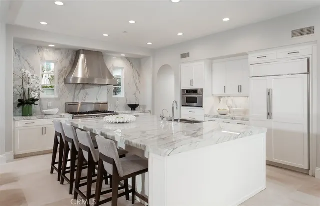 a kitchen with kitchen island granite countertop a sink a center island stainless steel appliances and cabinets