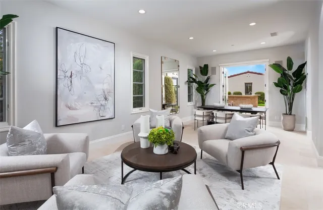 a living room with furniture potted plant and a painting on the wall
