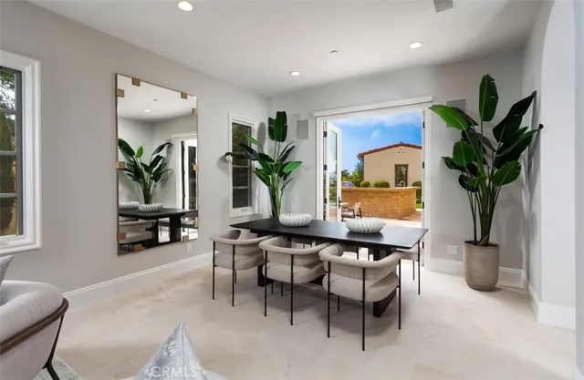 a living room with furniture a potted plant and a large window
