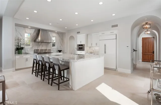 a large kitchen with white cabinets and stainless steel appliances